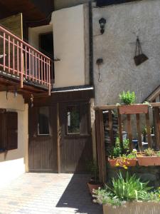 a house with a wooden door and a balcony at Appartement de montagne Briançon in Briançon