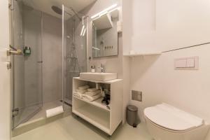 La salle de bains est pourvue de toilettes, d'un lavabo et d'une douche. dans l'établissement Apartment Adriatico Eterno 1, à Rovinj