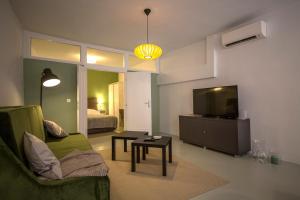 un salon avec un canapé vert et une télévision dans l'établissement Apartment Adriatico Eterno 1, à Rovinj