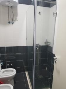 a bathroom with a toilet and a glass shower at Beach Garden Home, Lalzi Bay in Durrës +25 photos