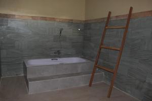ein Badezimmer mit einer Badewanne und einer Leiter in der Unterkunft Taman Padi Villa in Amed