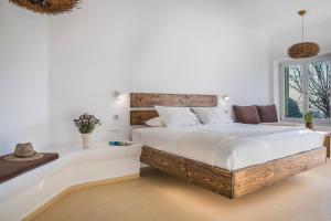 Un dormitorio blanco con una cama grande y una ventana en KLIDON Dreamy Living Suites en Mykonos ciudad