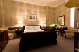 Un pat sau paturi într-o cameră la The Clarendon Hotel