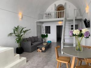 a living room with a couch and a table with flowers at Imer Villas in Imerovigli
