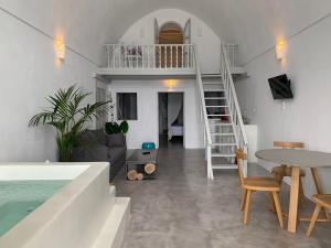 a living room with a staircase and a table and chairs at Imer Villas in Imerovigli
