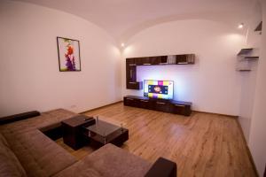 uma sala de estar com um sofá e uma televisão de ecrã plano em Heart of city apartament em Oradea