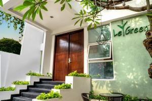 uma porta da frente de uma casa com escadas e plantas em LeGreen Suite Poso em Jacarta