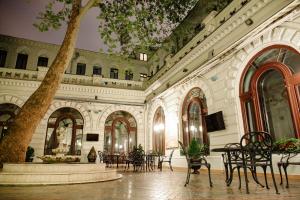 Londonska SPA Hotel في أوديسا: ردهة بها طاولات وكراسي وشجرة
