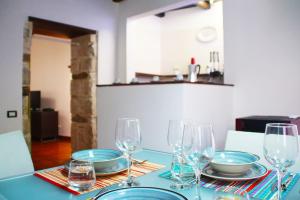einen Tisch mit Tellern und Weingläsern darauf in der Unterkunft Terrazzo Giudecca in the heart of Ortigia in Syrakus