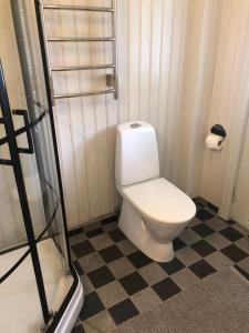 a bathroom with a toilet and a checkered floor at Jonstorps brygghus in Falköping