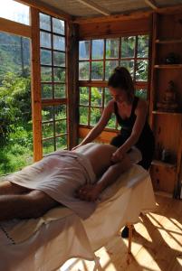 a woman cutting a mans leg on a bed at Hostal Casa Amaya in Vallehermoso