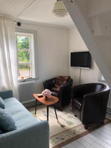 sala de estar con sofá, sillas y mesa en Jonstorps brygghus en Falköping