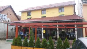 a store front with a building with a red roof at La Tusi Lovrin in Lovrin