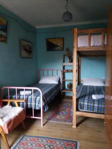 a bedroom with two bunk beds and a rug at At Home Hostel in Korçë