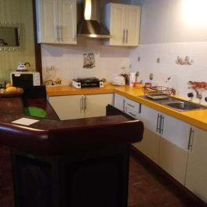 a kitchen with white cabinets and yellow counter tops at Don't Worry Be Happy in Jurien Bay