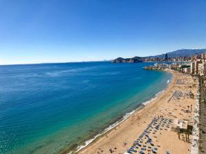 widok z lotu ptaka na plażę z parasolami i oceanem w obiekcie Torre Principado - Aloturin Benidorm w mieście Benidorm