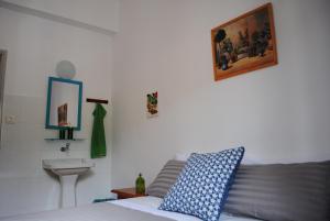 a bedroom with a bed and a sink and a picture at Hostal Casa Amaya in Vallehermoso