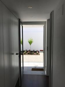 einen Flur mit einer Tür, die zu einer Pflanze führt in der Unterkunft CASA DO CABIDO - Elegance in simple traits in Évora