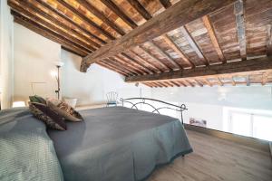 sypialnia z łóżkiem w pokoju z drewnianym sufitem w obiekcie Cavour Suite Mezzanine by 360Rentals we Florencji +10 zdjęć