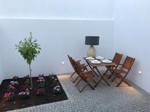 a dining room with a table and chairs and flowers at CASA DO CABIDO - Elegance in simple traits in Évora
