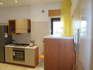 una piccola cucina con piano cottura e frigorifero di b&b aurora a Gravina di Catania
