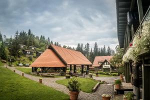 een gebouw met een paviljoen in een tuin met bomen bij Lobogo Resort in Vlăhiţa
