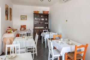 a dining room with white tables and white chairs at La BRIGNA B&B Il bosco sul mare in Genoa