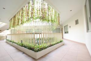 Habitación grande con ventana grande con plantas. en LeGreen Suite Penjernihan, en Yakarta