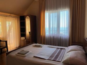 クヴァリアティにあるSanni Guest Houseのベッドルーム1室(大型ベッド1台、窓付)