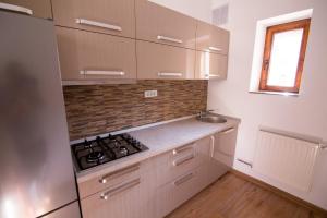 Una cocina con gabinetes blancos y un horno de estufa. en Heart of city apartament, en Oradea
