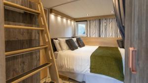 a bedroom with a bed in a room with shelves at Aberdunant Hall in Porthmadog
