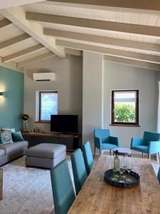 a living room with a table and blue chairs at Borgo Al Tempo Perduto in Gargnano