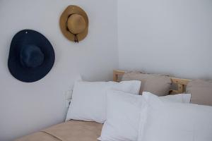 a hat on a wall next to a bed with pillows at Aquarella-stylish veranda apartment in centre of Poros town in Poros