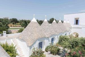 a white house with a tile roof at Relais Masseria Villa Cenci in Cisternino
