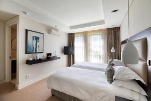 a hotel room with a bed and a television at Simola Hotel, Country Club & Spa in Knysna