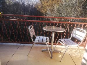 two chairs and a table on a porch at Hotel les Troenes in Montpellier