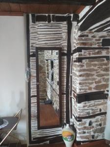 a mirror in front of a stone fireplace at Guesthouse To Petrino 1 in Keramídhion