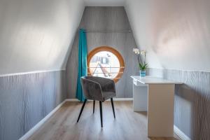 een kamer met een stoel, een bureau en een raam bij le ciel d'opale in Wimereux