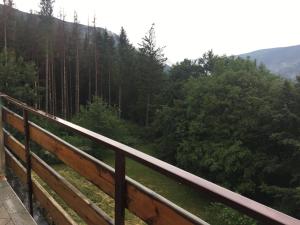 a view of a forest from a wooden railing at Casa Neve in Abetone