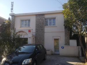 a black car parked in front of a white building at Hotel les Troenes in Montpellier