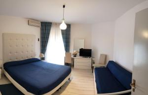 una camera con letto blu e televisore di Hotel King a Lido di Jesolo