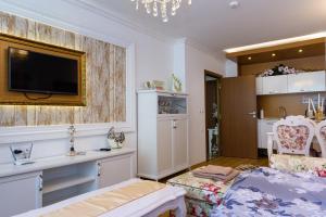 a bedroom with a bed and a tv on a wall at Sweet Homes Apartments in Sunny Beach