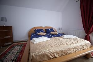 a bed with pillows on it in a bedroom at Muskatli Panzio Sic in Sic