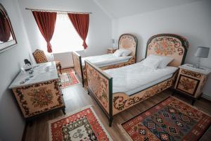 a bedroom with two beds and a table and a window at Muskatli Panzio Sic in Sic