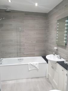 a white bathroom with a tub and a sink at The Osborne Hotel in Torquay