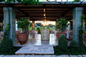 a covered patio with tables and potted plants at Rocco Forte Masseria Torre Maizza in Savelletri di Fasano