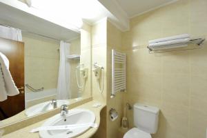 a bathroom with a sink and a toilet and a mirror at Hotel Moldova in Iaşi