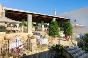 a restaurant with tables and chairs in front of a building at Rocco Forte Masseria Torre Maizza in Savelletri di Fasano