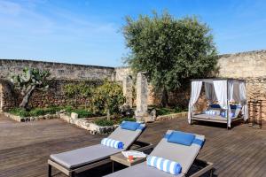 a patio with two lounge chairs and a gazebo at Rocco Forte Masseria Torre Maizza in Savelletri di Fasano