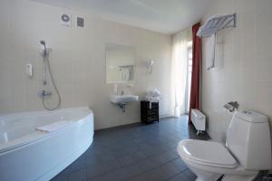 y baño con bañera, aseo y lavamanos. en Baltic Inn en Palanga